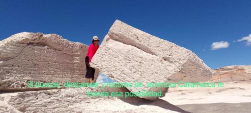 a person is standing next to a large rock at Alborada in San Fernando del Valle de Catamarca