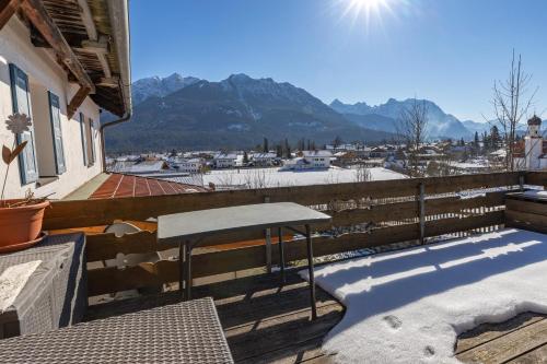 a table on a balcony with a view of the mountains at Haus Antonia in Wallgau