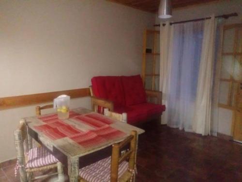 sala de estar con silla roja y mesa en Cabañas El Fogón en Potrerillos