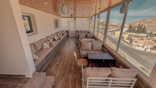 a room with couches and a table and a large window at Beit Alshabaan Inn in Wadi Musa