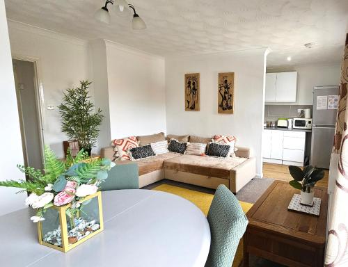 a living room with a table and a couch at 2 bed apt w/ private parking close to town centre in Huntingdon