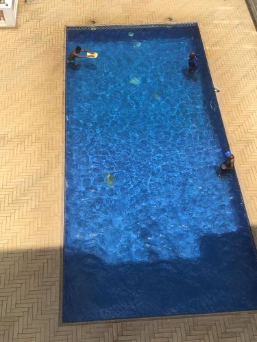 a large blue swimming pool with two people in it at The Penthouse oysterbay in Dar es Salaam