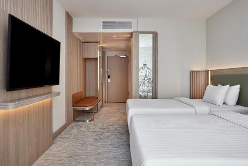 a hotel room with two beds and a flat screen tv at Courtyard by Marriott Berlin City Center in Berlin