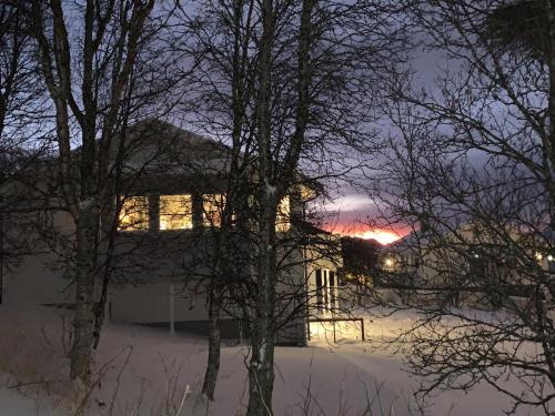 a house with the lights on in the snow at Villa top view Tromsø in Tromsø