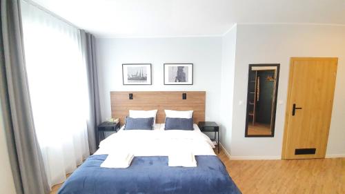 a bedroom with a large bed with a blue blanket at Sleep Port B&B - bezpłatny parking in Gdańsk