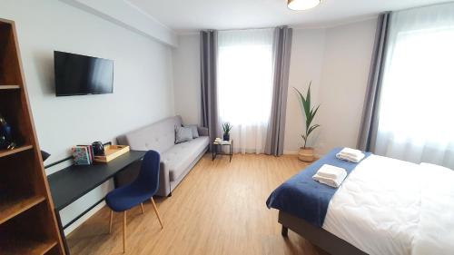 1 dormitorio con cama, escritorio y sofá en Sleep Port, en Gdansk