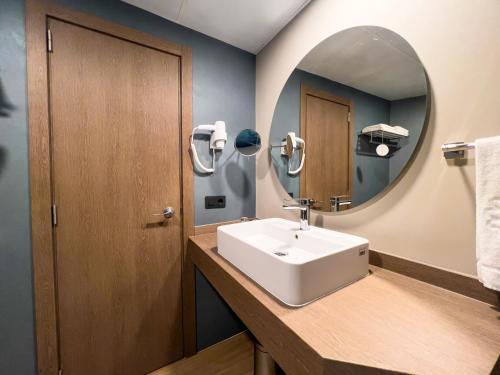 a bathroom with a sink and a mirror at Bahia Principe Sunlight Coral Playa in Magaluf