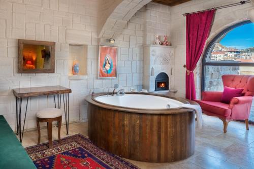 OrtahisarにあるMegaron Cave Hotel Cappadociaの広いバスルーム(バスタブ、椅子付)