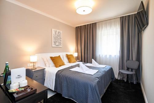 een hotelkamer met een bed, een bureau en een raam bij La Maison 
