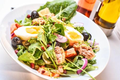 a salad with an egg on a white plate at La Maison in Adyliget