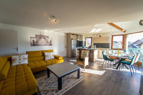 un salon avec un canapé jaune et une table dans l'établissement Les charmes du lac, à Saint-Jorioz