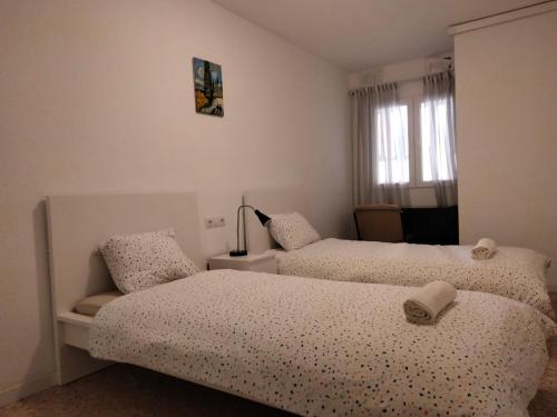 a bedroom with two beds and a window at Castellon Center Modern Spacious Apartment in Castellón de la Plana