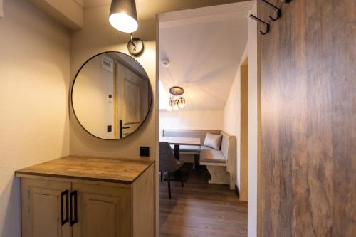 a bathroom with a vanity and a mirror and a table at MONDI Hotel Axams in Innsbruck