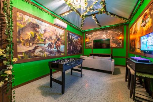 a room with green walls and a table with a chessboard at Magical Themed Home - Disney 15 min in Kissimmee