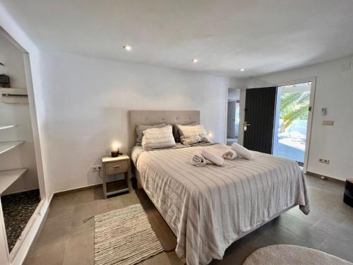 una camera bianca con un letto e una finestra di Perla Blanca by Sun & Sea Homes a Benissa
