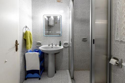 a small bathroom with a sink and a shower at Seaside Flat with Scenic Country Views in Mellieħa