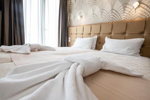 a bedroom with two beds with white sheets and pillows at Athens Golden City Hotel in Athens