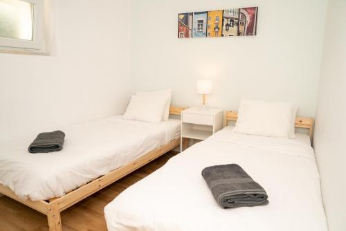 two twin beds in a room with white walls at 2 Bedroom Apartment House - Sol do Murtal in Parede
