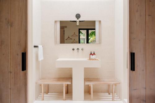a bathroom with a sink and two benches at Good Hotel Antigua in Antigua Guatemala