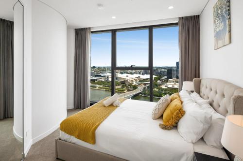 een slaapkamer met een groot bed en een groot raam bij CASSA ONE - Luxury Apartments Managed by The Cassa in Brisbane