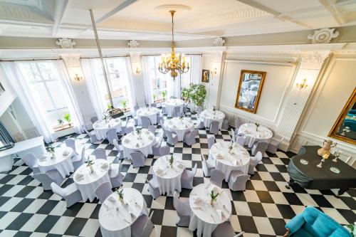 Hotel Solar Palace SPA & Wellness في مارونجوفو: غرفة بطاولات بيضاء وكراسي وثريا