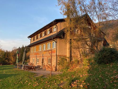 a large brick building with a picnic table in front of it at Chata Ostrá Ostravice in Ostravice