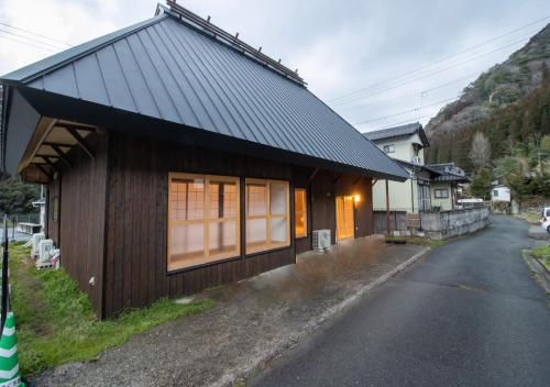a small house on the side of a road at 予約制薪割りBBQ可能! 青の洞門から車で15分 l 四季折々の自然が楽しめる農泊古民家 鍋屋 in Sugihata