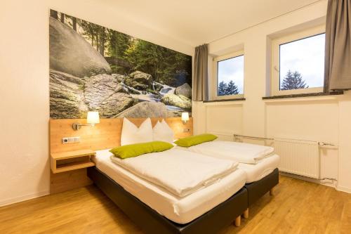 una camera con due letti e un dipinto sul muro di 2 Raum Wohnung Superior a Schulenberg im Oberharz