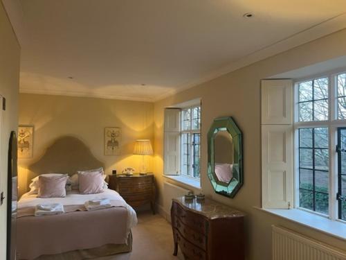 a bedroom with a bed and a dresser and a mirror at Pass the Keys Sunset House18th cent cottage stunning garden in Chipping Norton