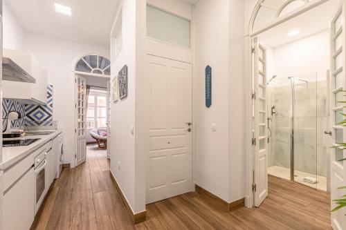 a bathroom with a shower and a white door at Green-Apartments Mansión Blue Catedral in Seville