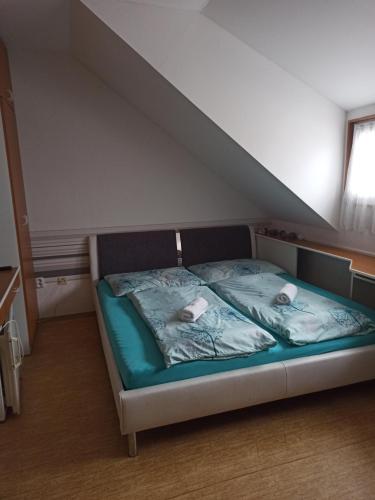 a bed with two pillows on it in a room at Penzion Pasohlávky in Pasohlávky