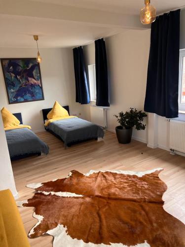 ein Wohnzimmer mit 2 Betten und Holzboden in der Unterkunft Rust-Appartements-II-Marienrode in Hildesheim