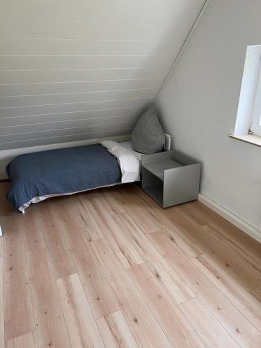 a small bedroom with a bed and a wooden floor at Rust-Appartements-II-Marienrode in Hildesheim