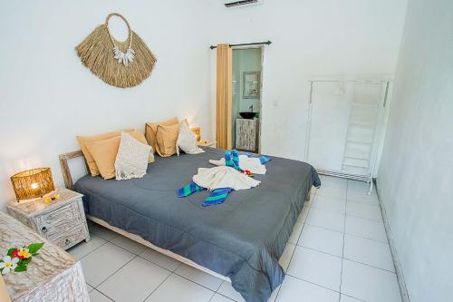 - une chambre avec un lit et des vêtements dans l'établissement Naturale Guest House, à Nusa Lembongan