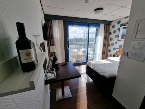 una habitación con una botella de vino en la pared en Eemshotel, en Delfzijl