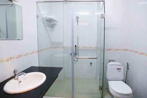 uma casa de banho com um chuveiro, um WC e um lavatório. em Mittaphap Hotel Oudomxai em Muang Xai