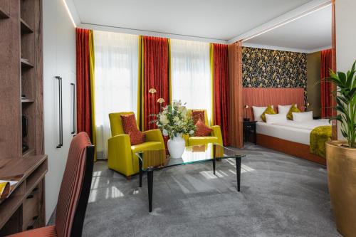 a hotel room with a bed and yellow chairs at Hotel BEI SCHUMANN in Kirschau