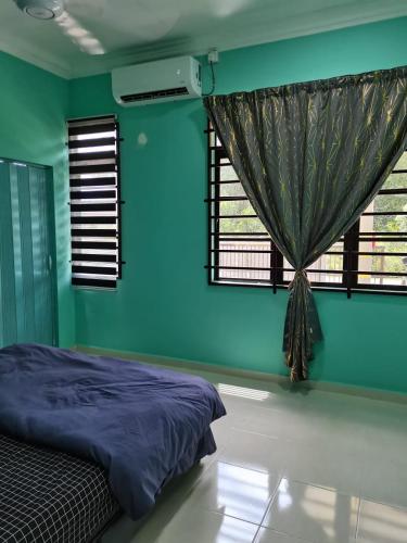 a bedroom with blue walls and a bed with a window at Makmur Homestay Marang in Marang
