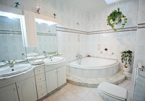 a bathroom with two sinks and a tub and a toilet at Apartamentos Caleiro 6P - Vilanova de Arousa in Villanueva de Arosa