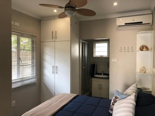 - une chambre avec un lit et un ventilateur de plafond dans l'établissement 8 Ocean Drive Self Catering Unit, à Ballito