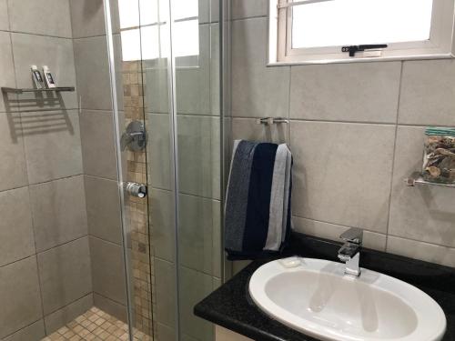 a bathroom with a sink and a shower at 8 Ocean Drive Self Catering Unit in Ballito