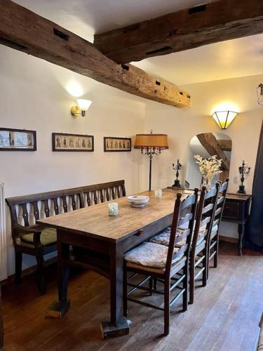 a dining room with a wooden table and chairs at Charmante maison de caractère à 2Km de Redu in Libin