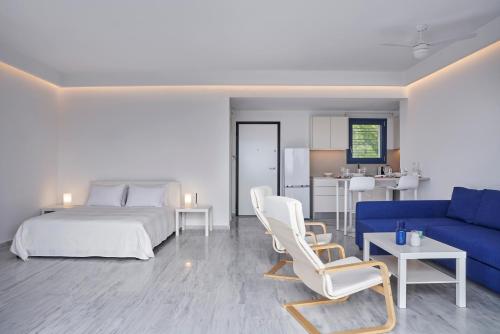 a bedroom with a bed and a blue couch at Augoustos ECO luxury apartments in Aghia Marina