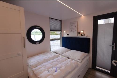 1 dormitorio con 1 cama grande y ventana en Hausboot Fjord Dory mit Biosauna in Schleswig, en Schleswig