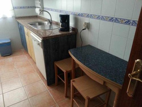 una pequeña cocina con fregadero y encimera en PlayaWifi2 dorm2 baños6 persParking cerrado, en Chipiona