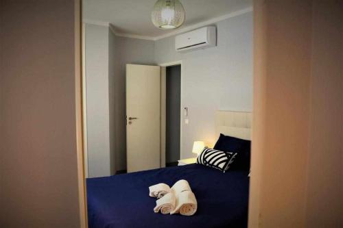 Un dormitorio con una cama azul con toallas. en AlgarveSand Carvoeiro, en Carvoeiro