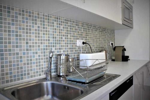 a kitchen sink with a dish rack on it at AlgarveSand Carvoeiro in Carvoeiro