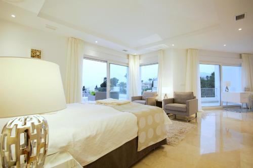 - une grande chambre avec un grand lit et une chaise dans l'établissement Exquisite Villa Near Beach - Heated Pool, à Marbella