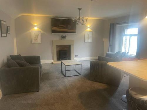 - un salon avec des canapés et une cheminée dans l'établissement Immaculate 2-Bed Apartment above Village Pub, à Buxton