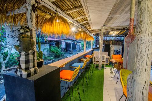 un restaurant avec un bar avec des chaises et des tables dans l'établissement Naturale Guest House, à Nusa Lembongan